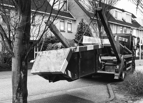 Collection crew wearing PPE beside a commercial bin